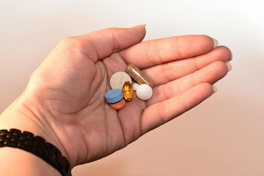 Hand holding pills showing long-term PPI use and the need for natural acid reflux and GERD alternatives.